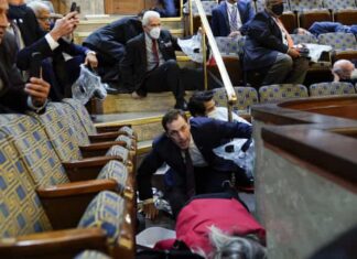People shelter in the House gallery as rioters try to break into the House Chamber at the Capitol on 6 January. Trump’s impeachment trial will be held at the same place the violence unfolded.